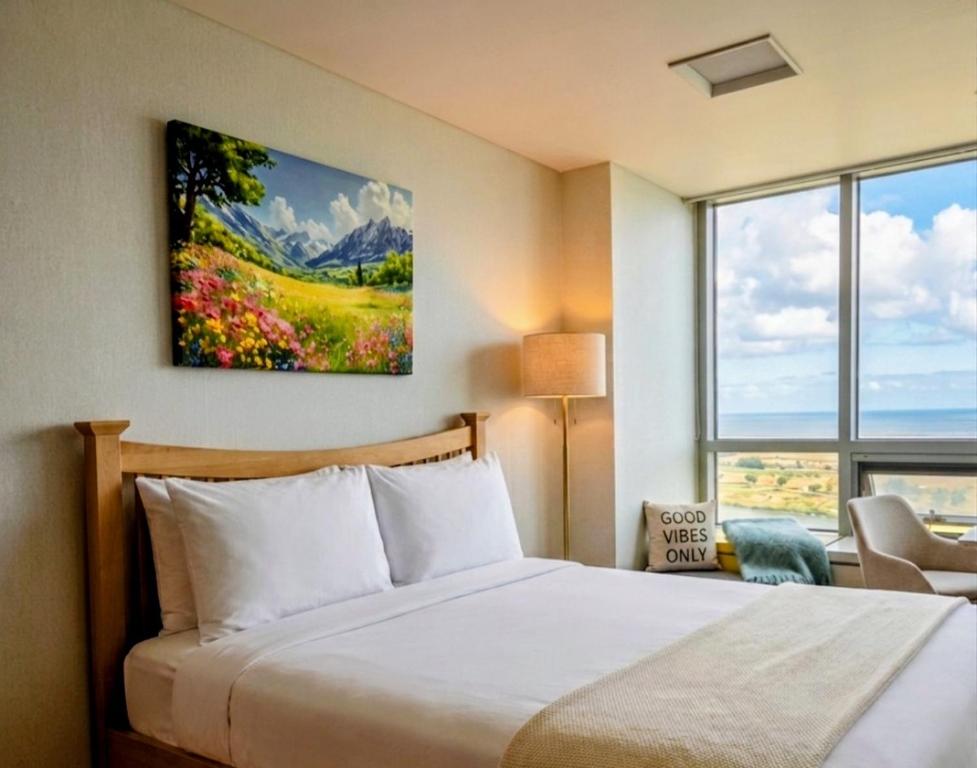 a bedroom with a bed and a large window at Cozy - Sunny Studio in Incheon
