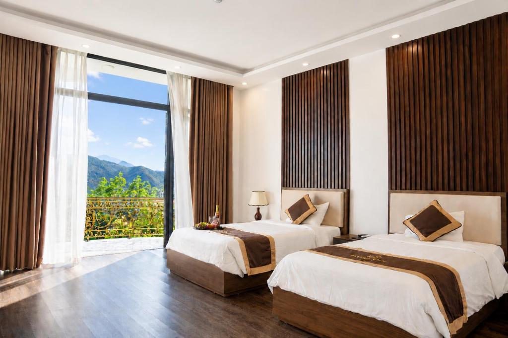 a hotel room with two beds and a large window at Hoàng Liên Hotel in Na Cốc