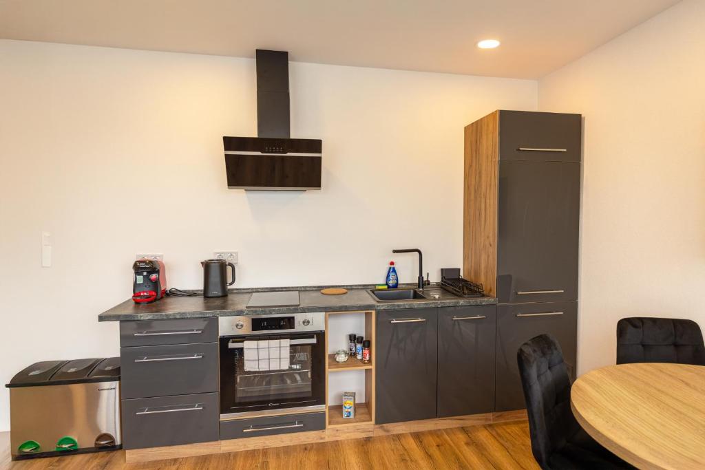 a kitchen with stainless steel appliances and a table at M4 Apartment New in Freiburg im Breisgau