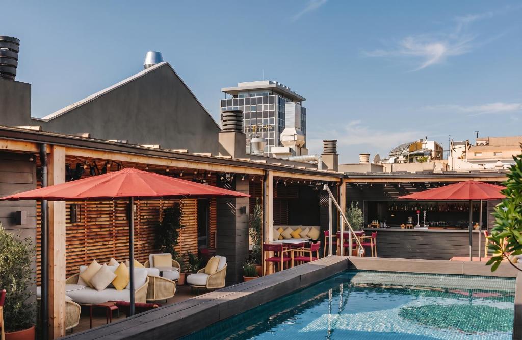 a pool with chairs and umbrellas on a building at Catalonia Boulevard 4 Sup in Barcelona