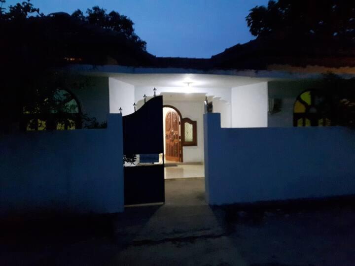 a house with a blue and white wall and an entry way at Sajee Residence Nilaveli in Trincomalee