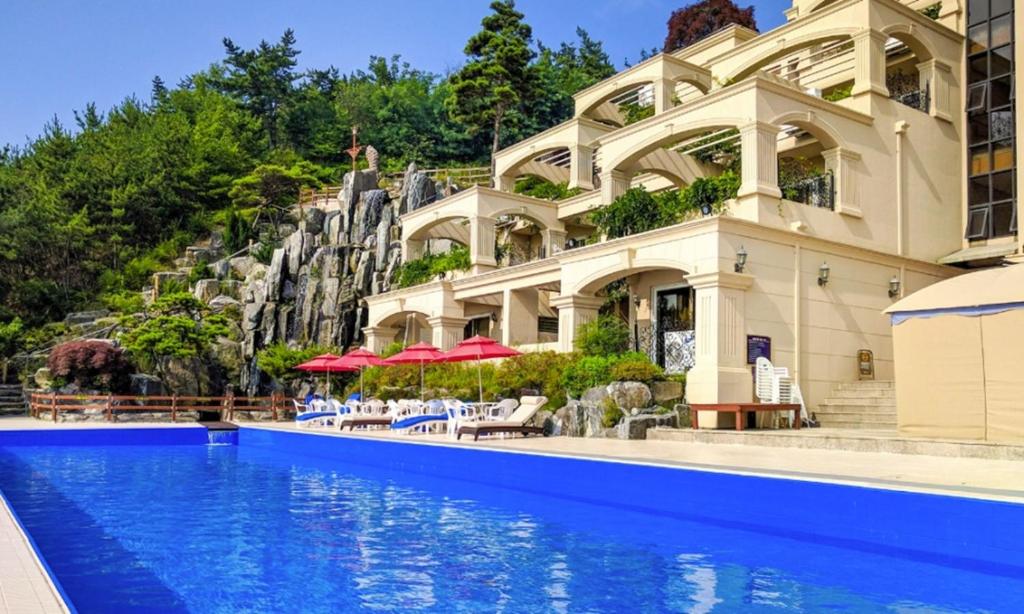 a house with a swimming pool in front of a building at Seosansoo Golf & Resort in Seosan