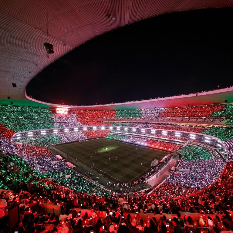 a crowd of people watching a soccer game in a stadium at Estadio Azteca Banorte Suites in Mexico City