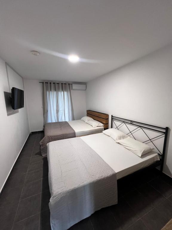 a room with two beds and a television in it at Salt & Sea in Sykia Chalkidikis