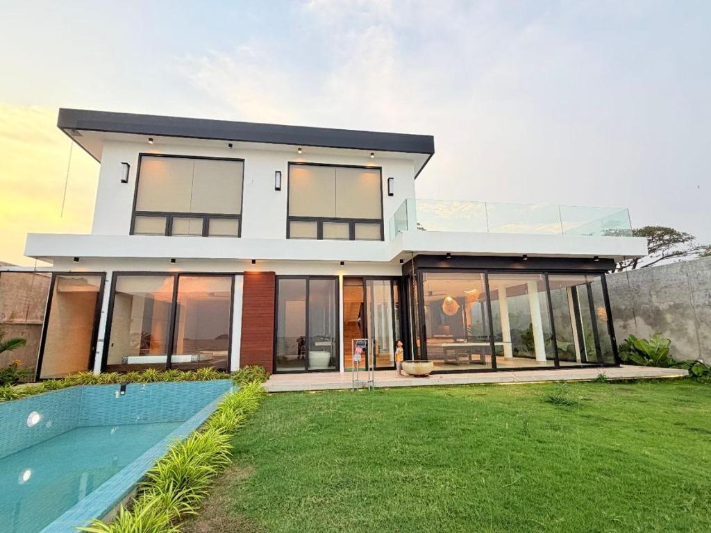 a large house with a swimming pool in front of it at Sabi by the Sea Kep in Kep