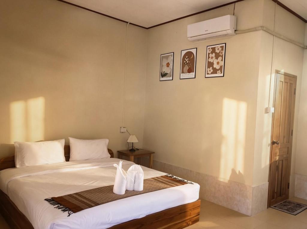 a bedroom with a bed with two white towels on it at XAIYASITH guesthouse in Nongkhiaw