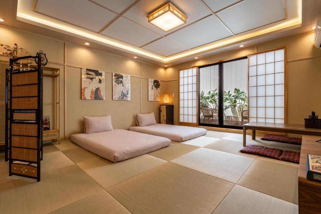 a room with two beds and a desk at 楓 和室の一棟貸切 最大10名宿泊可能 駅徒歩2分 関西空港直通 in Osaka