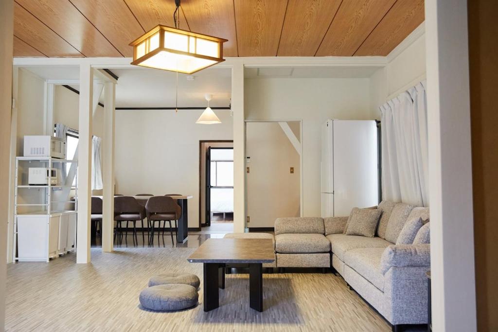 a living room with a couch and a table at Knot Kyonan in Katsuyama