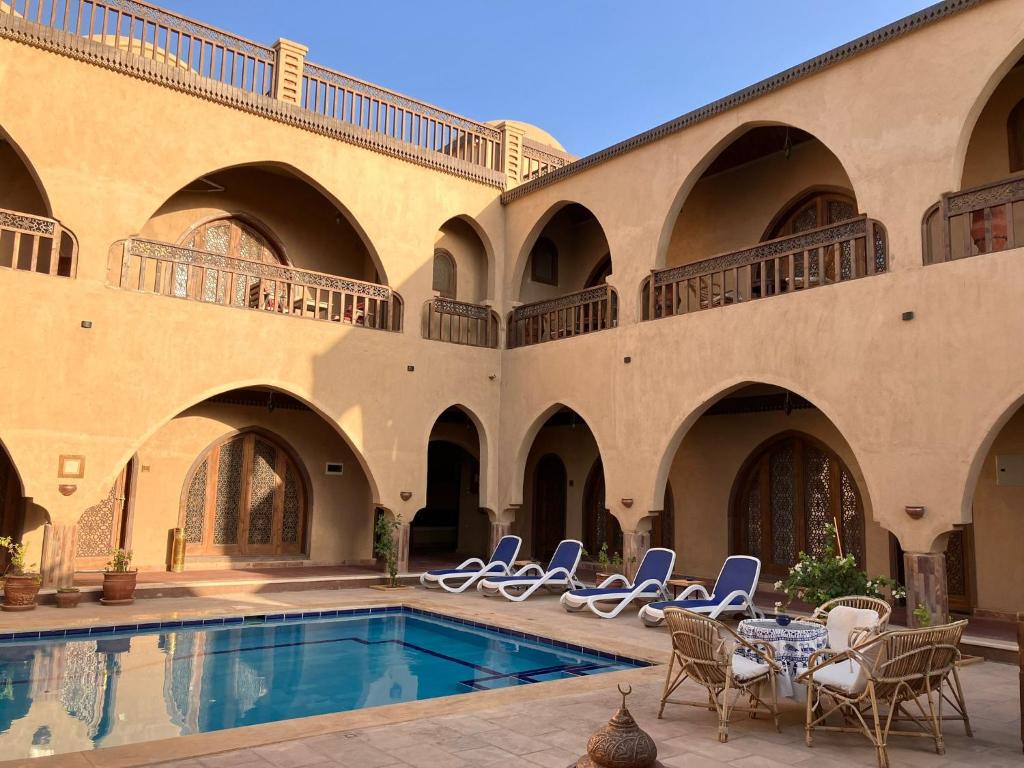 a courtyard with chairs and a swimming pool at Sultana Palace in ‘Ezbet Abu Ḥabashi