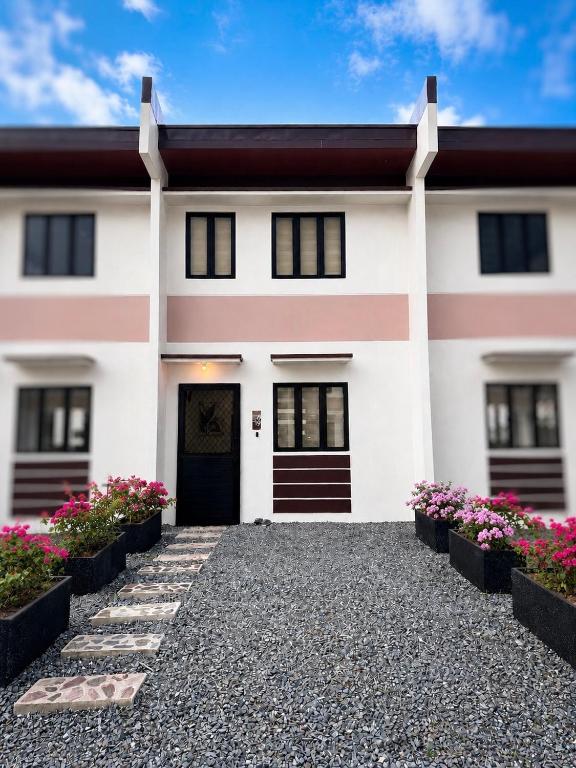 a white house with black doors and flowers at Idesia Lipa Custodio Suites in Lipa
