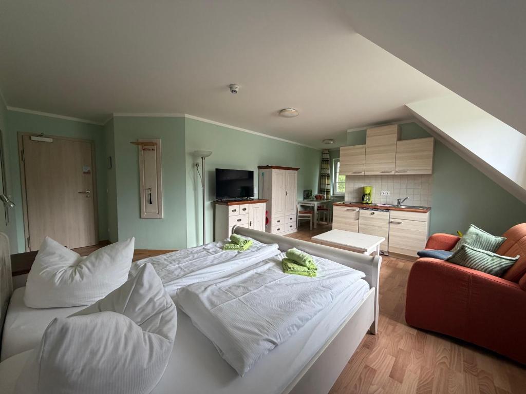 a room with a bed with pillows and a kitchen at Spreewälder Feriendomizil/Pension in Burg