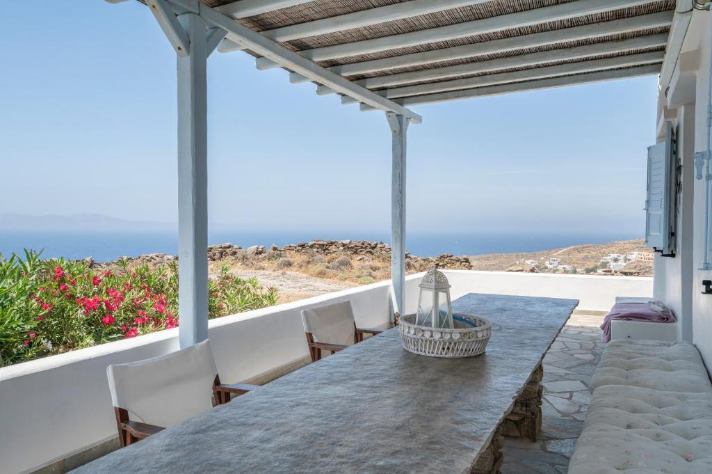 a dining table on a patio with a view of the ocean at Tinos Sunset House in Tinos