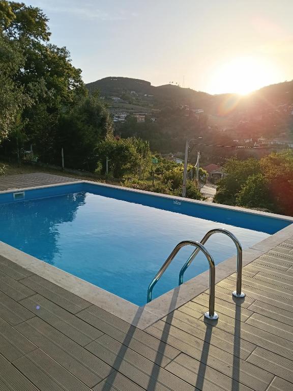 a blue swimming pool with a view of a city at Casa dos Leme in Baião