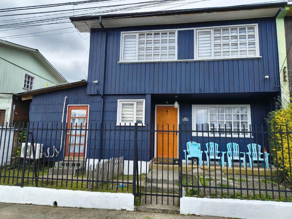 a blue house with a fence in front of it at Casa completa para 6 personas centro Puerto Montt, 700 metros estatua enamorados in Puerto Montt