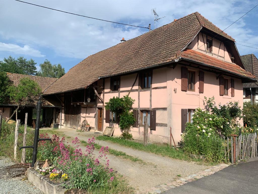 an old house with flowers in front of it at Ferme Alsacienne in Soppe-le-Haut