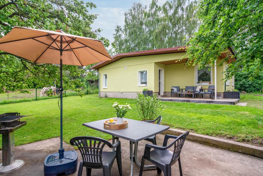 a table with chairs and an umbrella in a yard at Ferienhaus Kleine Auszeit in Bleicherode