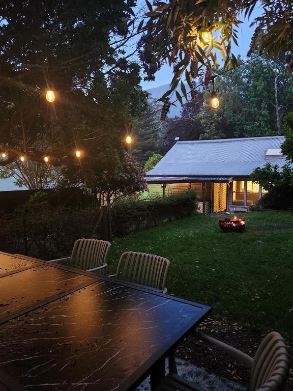 a table and chairs in a yard at night at Red Gum & Stone - Peace Space Nature in Warburton
