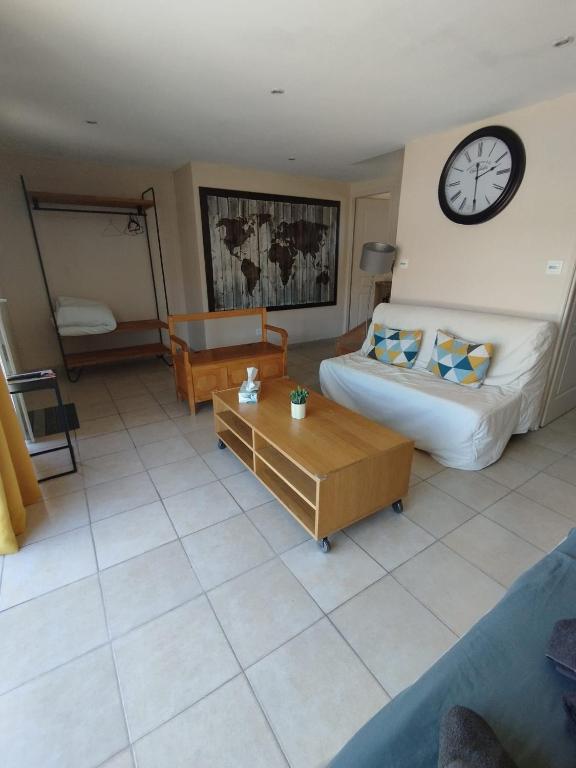 a living room with a bed and a clock on the wall at Studio La Gière in Beaumes-de-Venise