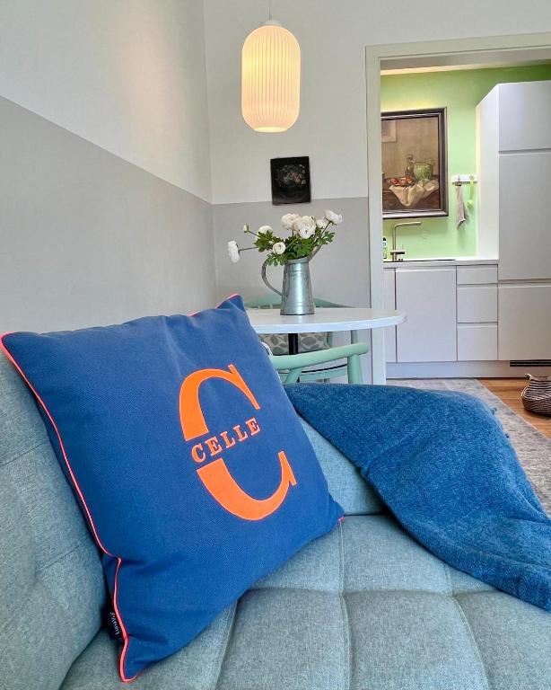 a blue couch with a calidas pillow on it at Apartment am Freitagsbach in Celle