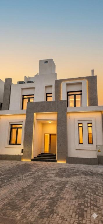 a large white house with a brick driveway at Paradise in Al Khīrān
