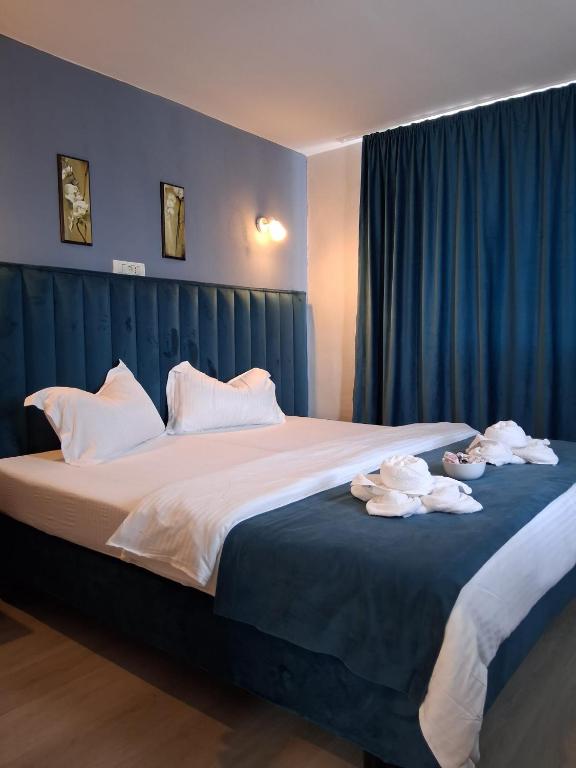 a bedroom with a large bed with towels on it at ADMAR Rooms & Restaurant in Costinesti