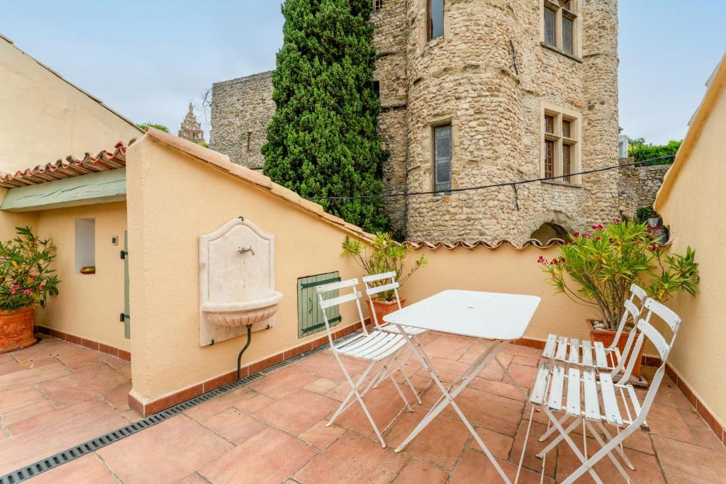 a table and chairs on a patio in front of a building at Amour de Provence in Nyons