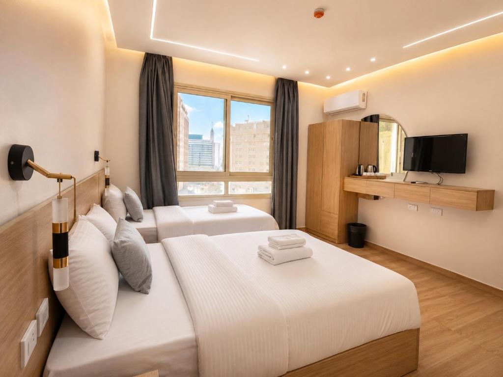 a hotel room with two beds and a television at Landmark Hostel Cairo in Cairo