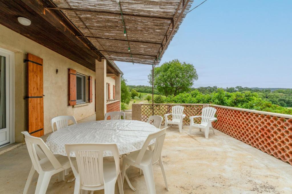 a table and chairs on a balcony with a table and chairs at Gîte La Motette Drôme Provençale in Rousset-les-Vignes