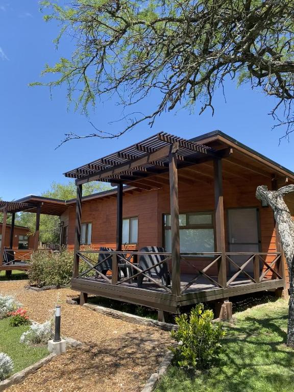 a log cabin with a roof over a porch at Cabañas Boutique Pipi Cucu in Colón