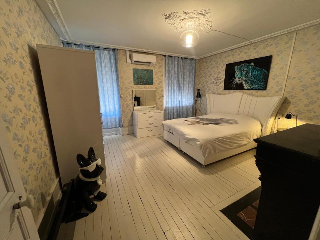 a bedroom with a white bed and a room with aearcher at Chambre bleue in Vigneulles-lès-Hattonchâtel