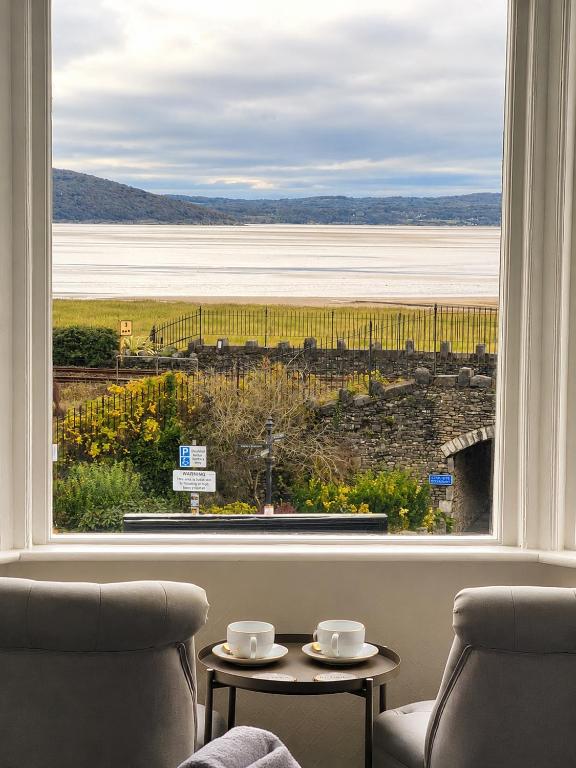 a room with a large window with two chairs and a table at The Commodore Inn in Grange Over Sands