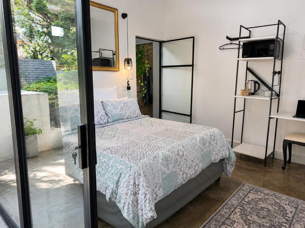 a bedroom with a bed and a glass door at 16 st Johns - Studio 2 in Port Shepstone