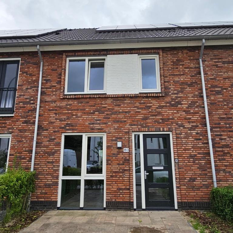 a brick house with two windows and a door at Residence Oosterhout in Den Hout
