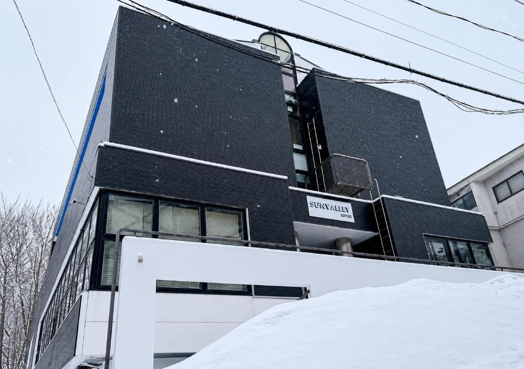 a black building with a sign on the side of it at Zao Sunvalley Hotel in Yamagata