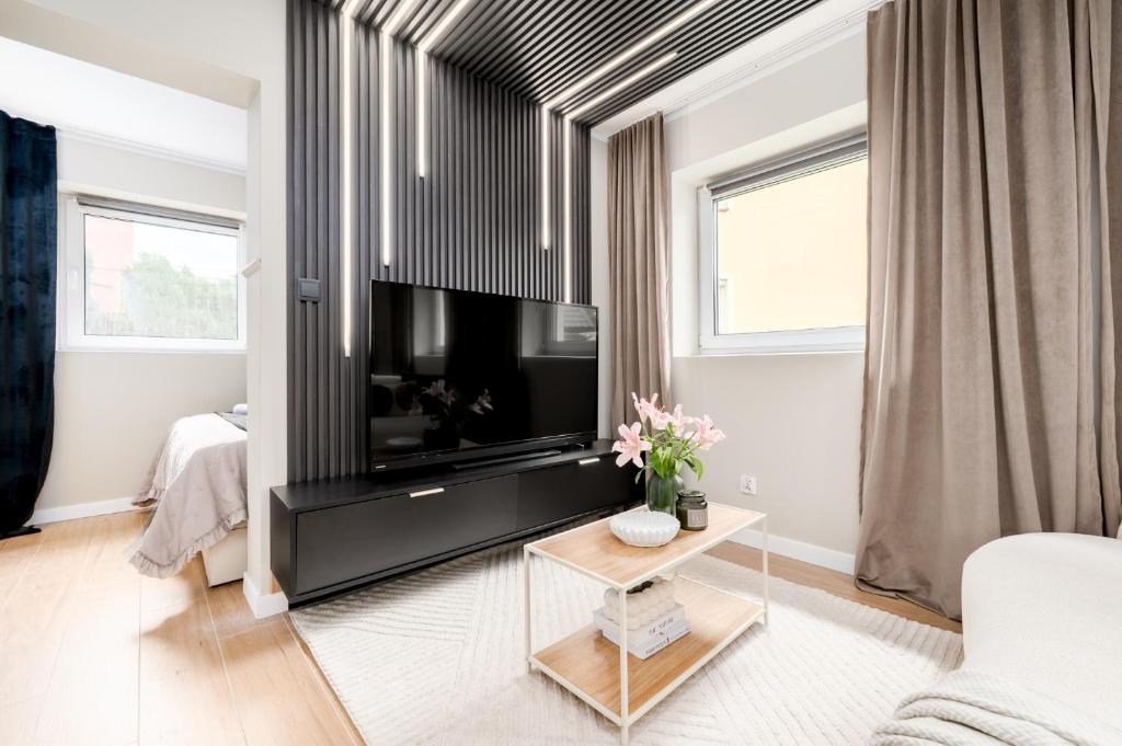 a living room with a large flat screen tv at Aparthotel Cieplice in Jelenia Góra
