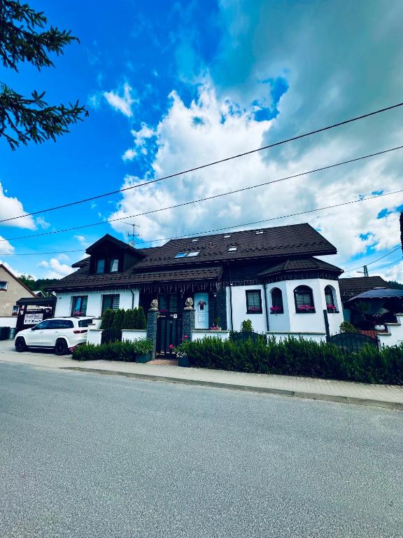 a white house on the side of a street at Penzión BACH in Vyšné Ružbachy