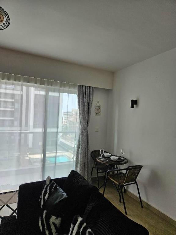 a living room with a couch and a table and a window at Pinnacle suites in Nairobi