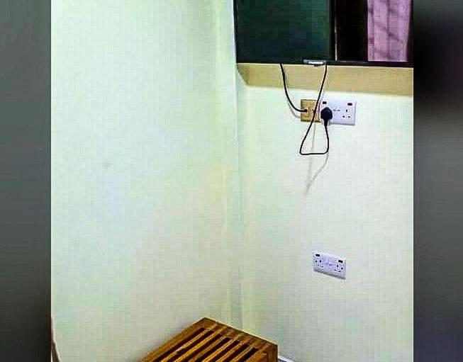 a room with a white wall with a refrigerator at Wisny Guest House in Kasoa