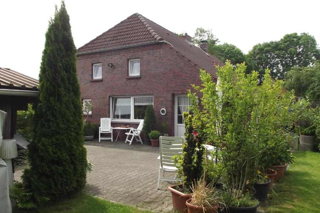 a house with a table and chairs in the yard at Landhaus beim See in Großheide