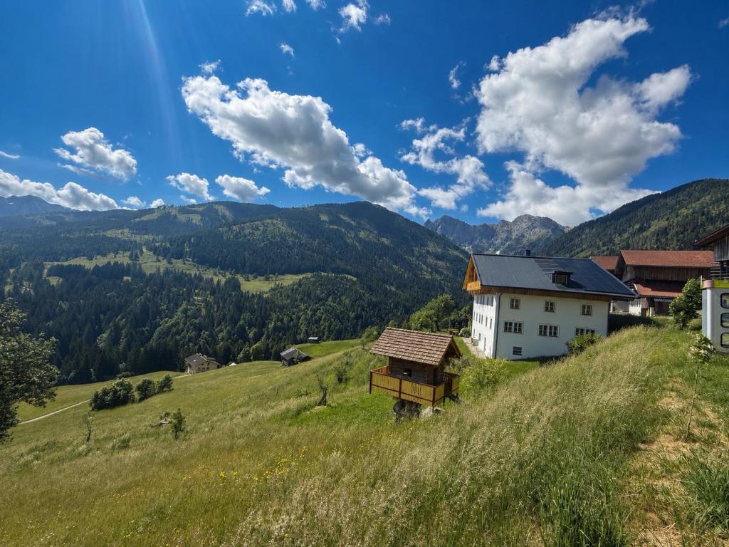 a house on a hill with mountains in the background at Hepi Lodge in Liesing
