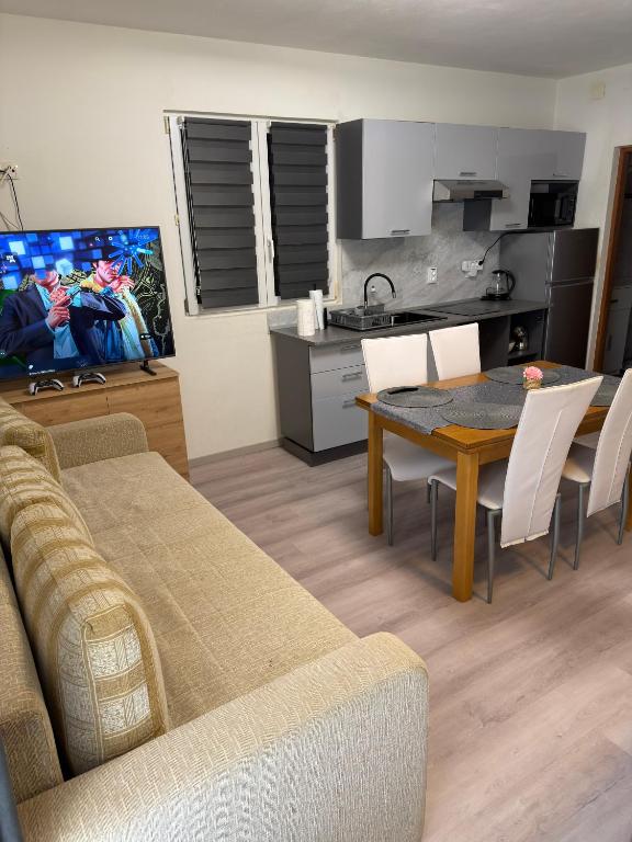 a living room with a table and a kitchen at Apartman J&B in Vir