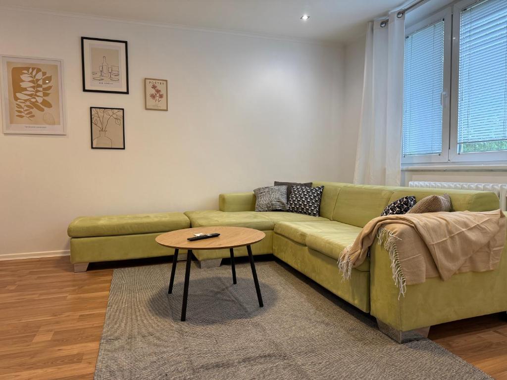 a living room with a green couch and a table at Príjemný apartmán Trnava in Trnava