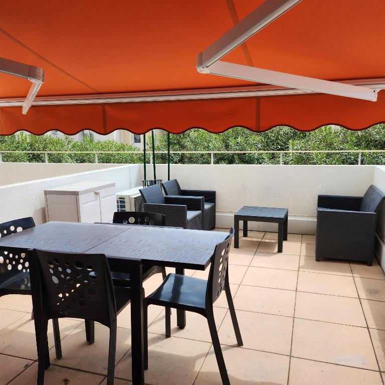 a table and chairs and an umbrella on a patio at Studio avec grande terrasse in Carnon-Plage