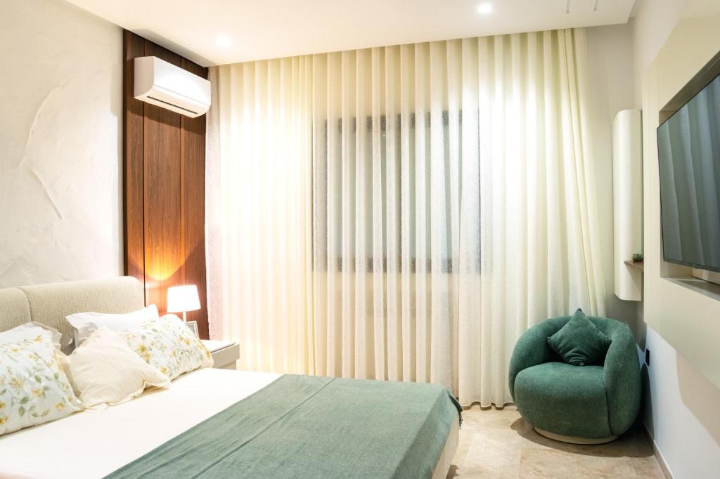a bedroom with a bed and a green chair at Dar Mustapha in Tunis