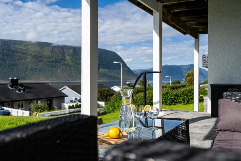 a glass table on a patio with a view of a mountain at Mountain View Apartment, Free Parking, Hiking Nearby in Ålesund