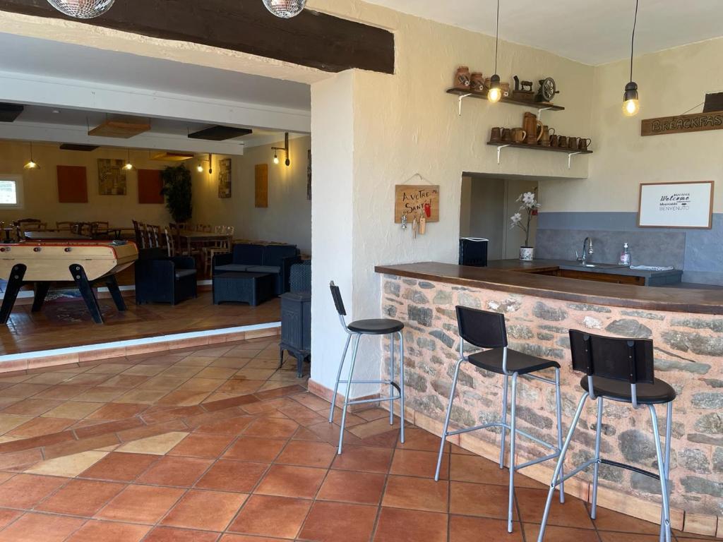 a bar in a restaurant with chairs and a table at gîte 19 personnes in Rogues