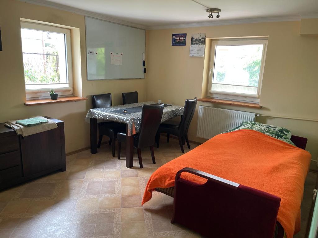 a room with a table and chairs and a bed at Kwatera przed remontem BEZ zlewu w części kuchennej łazienka sprawna ale PRZED REMONTEM in Gdynia