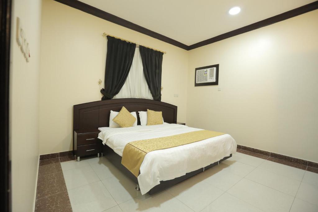 1 dormitorio con 1 cama grande en una habitación en Alrosa Furnished Apartments, en Buraidah