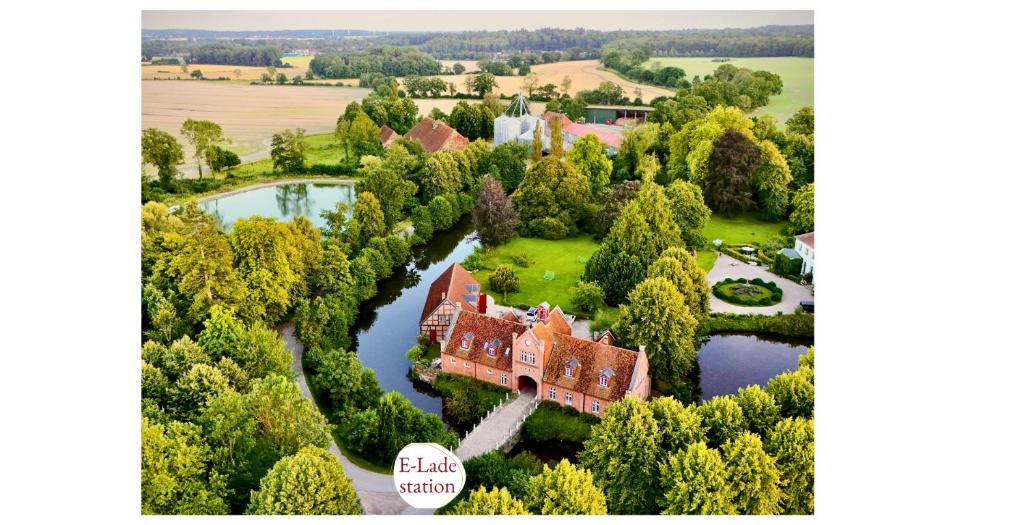 an aerial view of a mansion with a river at Gut Petersdorf Lensahn - ideal für Familien und Hunde - mit Kamin, Parkblick, Terrasse, eingezäuntem Garten und E-Ladestation in Lensahn