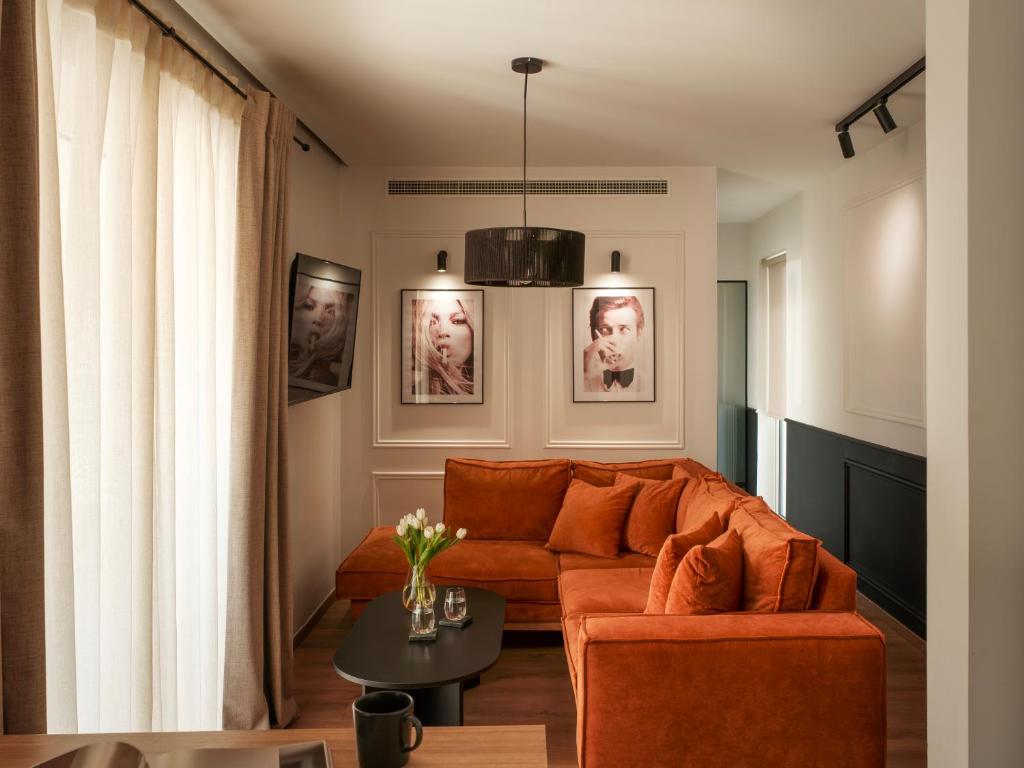 a living room with an orange couch and a table at Nostos - Luxury Apartment in Agrinio in Agrinio